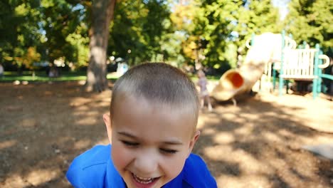 Happy-little-boy-on-playground-throws-his-head-back-and-laughs-in-slow-motion