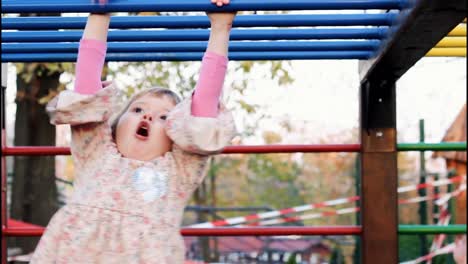 una linda niña hace ejercicio en barras de mono