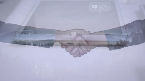 animation of businessman handshake over social media icons and tablet