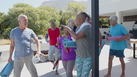 happy diverse senior friends talking after yoga in sunny garden, unaltered, in slow motion