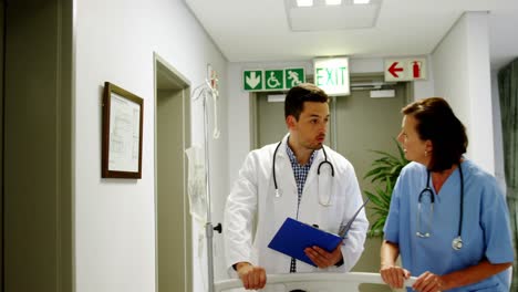 doctors discussing over medical report while rushing a patient on emergency room