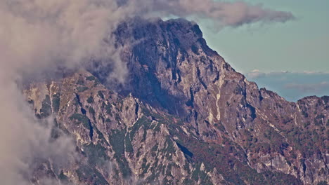 Massive-rocky-mountain-and-clouds,-aerial-drone-view