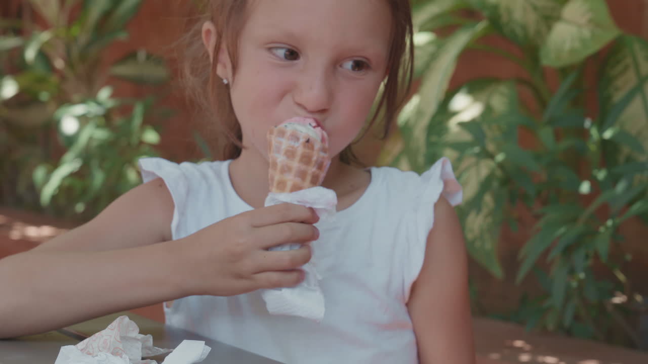 прекрасная кавказская девушка ест мороженое на открытом воздухе
