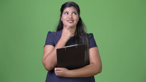 joven sobrepeso hermosa mujer de negocios india contra fondo verde