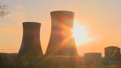 time lapse shot of the sun setting behind a nuclear power plant