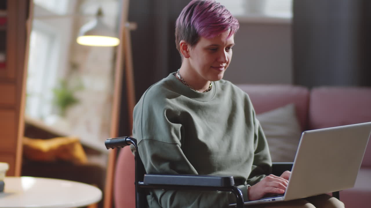 mujer en silla de ruedas trabajando en una computadora portátil