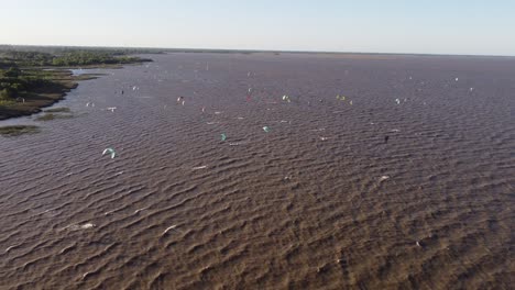 Aerial-view-kitesurfers-speeding-with-kites-in-sunset-Argentina