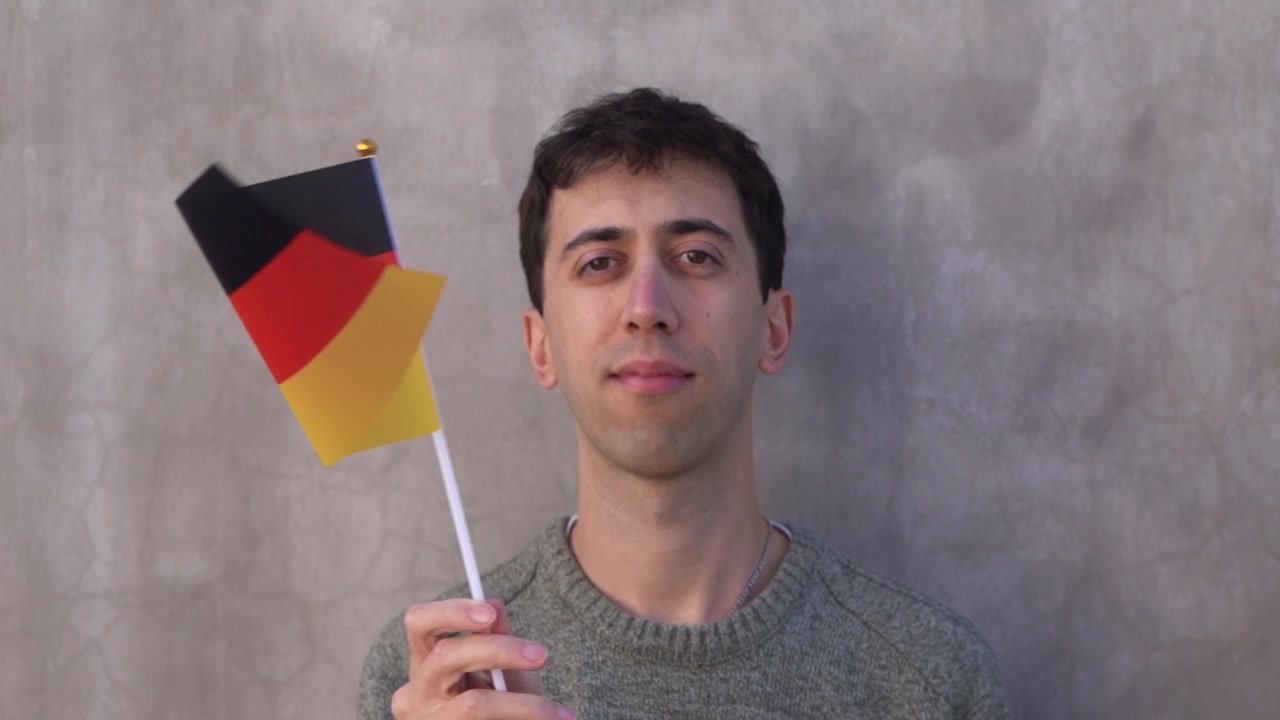 Uomo adulto che sventola la bandiera della Germania. Slow motion. Primo piano.