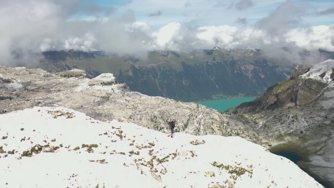 혼자 있는 청년이 완벽한 전망을 얻기 위해 산꼭대기 쪽을 조심스럽게 천천히 걷고 있다
