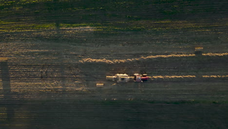 Antena-De-Arriba-Hacia-Abajo-Del-Tractor-Que-Deja-Caer-Una-Paca-De-Tallos-De-Maíz-En-El-Campo-Pennsylvania,-U