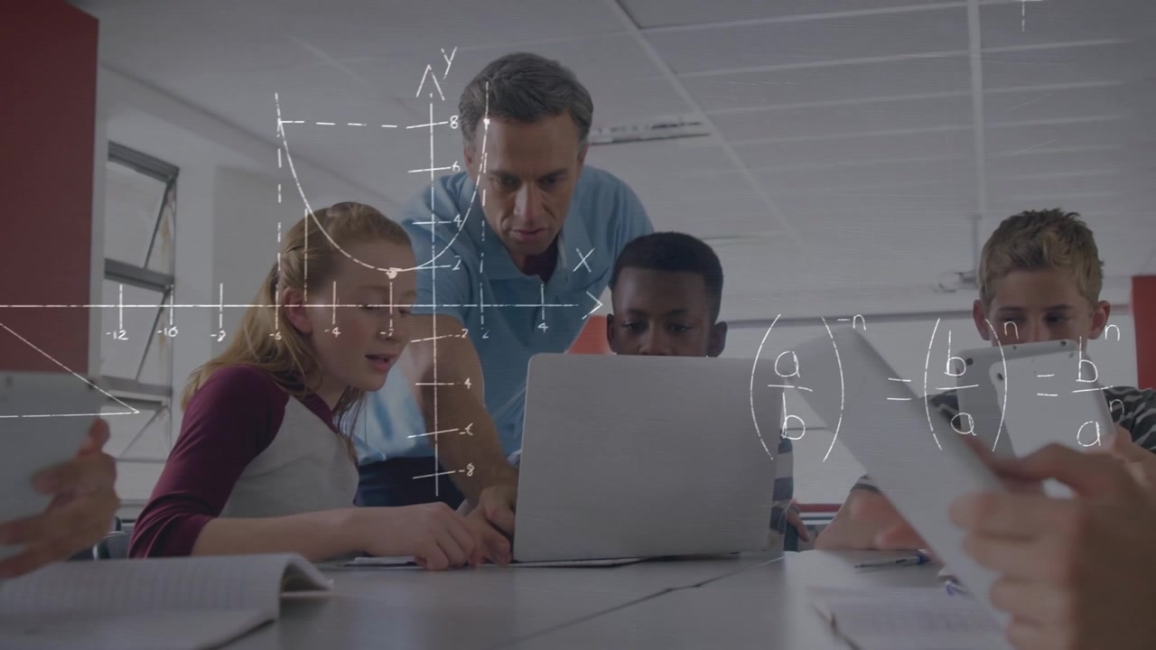 Teacher Helping Students with Math Lesson on Laptop in Classroom