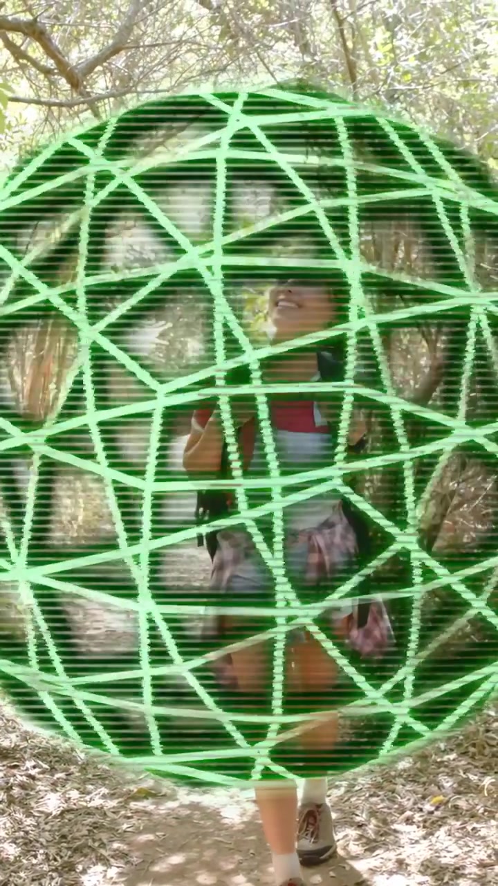 Video verticale: Donna che scende un sentiero nel bosco per fare fitness, sistemando le cinghie, con una griglia al neon che crea un effetto glitch sulla visuale.