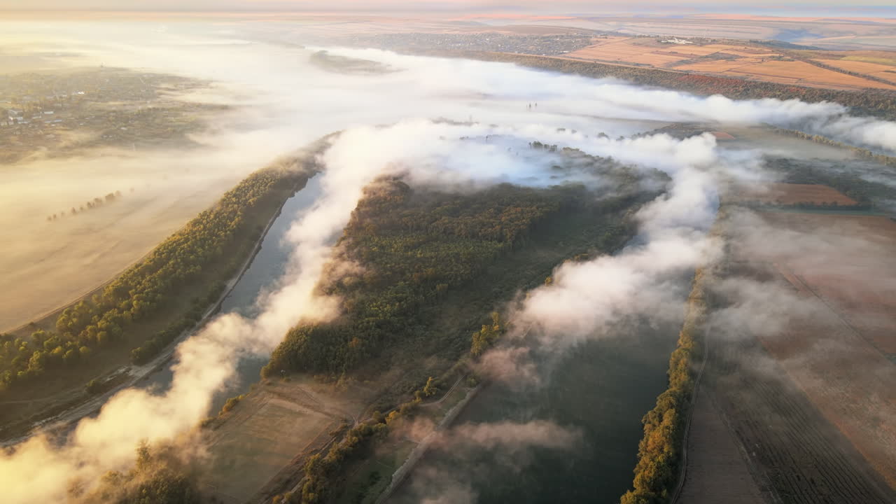 Aerial drone view of nature of Moldova at sunset. River and lush fog above it, village, greenery
