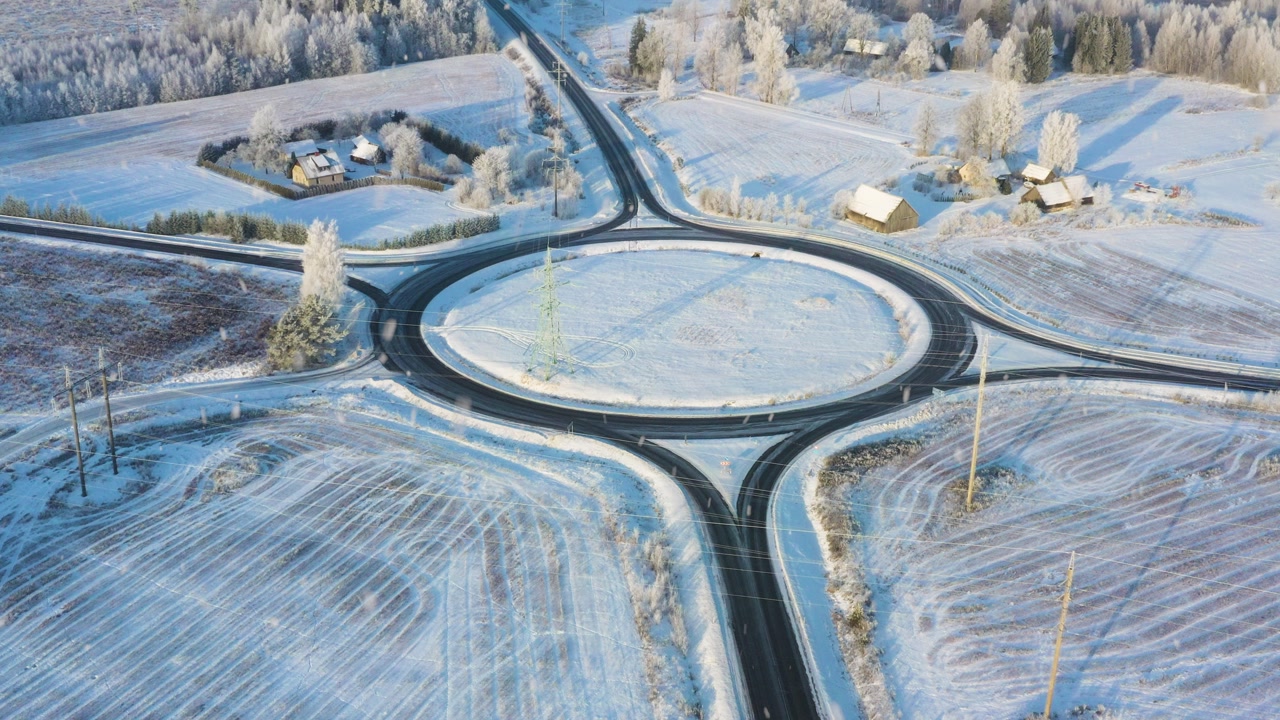 Winter roundabout system connecting roads, offering transport and travel in aerial view