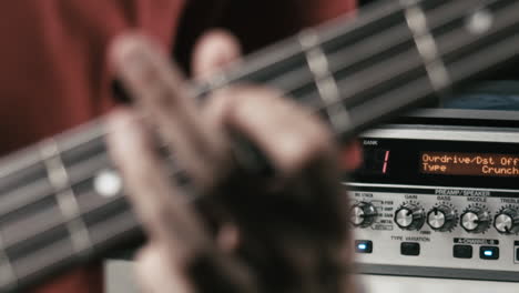 Musician-plays-bass-guitar-in-his-own-studio,-close-up-of-the-hand-on-the-neck