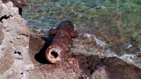 Old-rusted-cannon-washed-up-on-the-shore-of-an-island-in-the-Caribbean