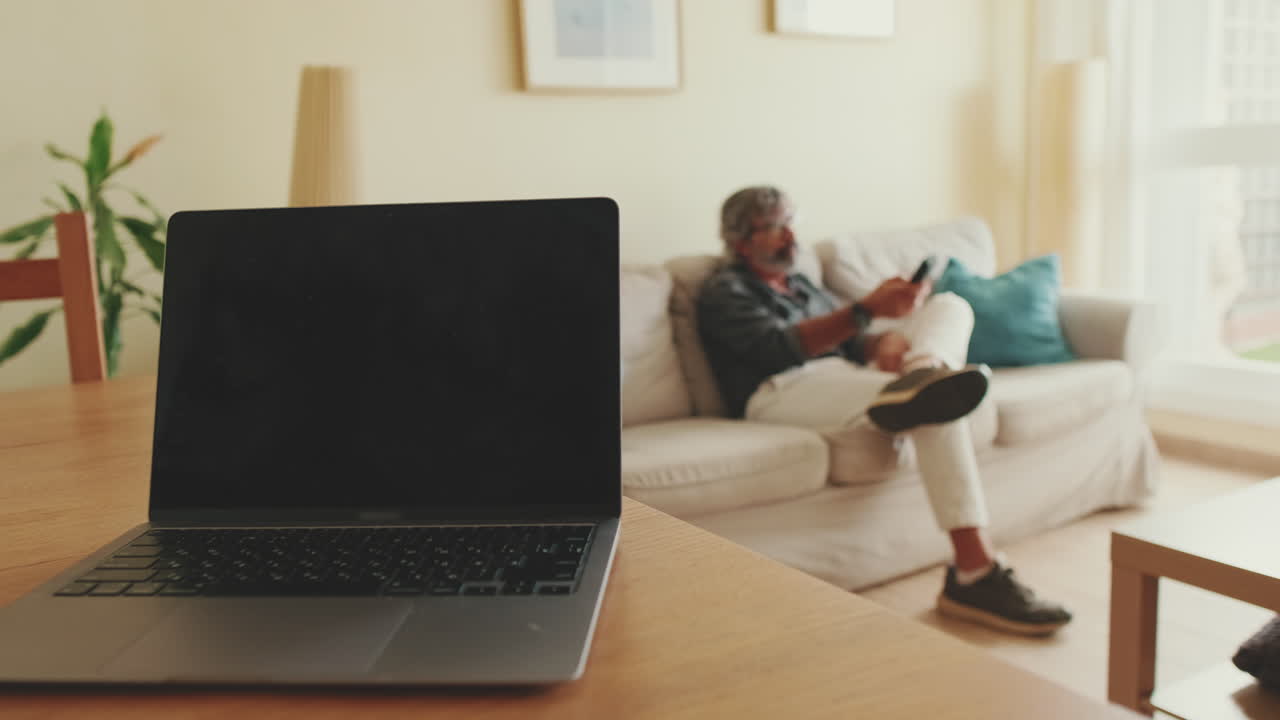 Modern Living Room with Laptop and Man on Couch