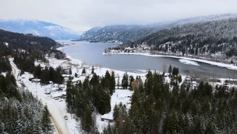 snowy wonderland of adams lake and mountainous forests, drone flight overhead