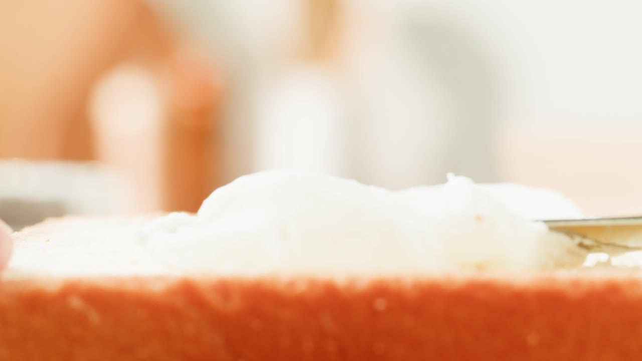 Spreading cream cheese on bread