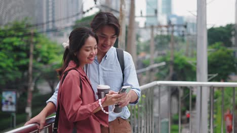 young couple enjoying coffee and mobile phone outdoors