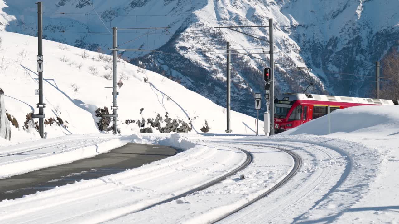 tren panorámico rojo que pasa en un día soleado en las montañas en alp grum, suiza
