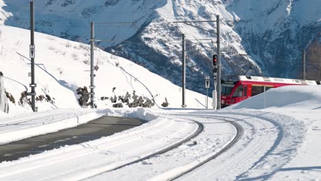 red panorama train passing on a sunny day in the mountains in alp grum, switzerland