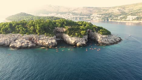 aerial view of a group of tourists on a kayak tour passing by lokrum island near dubrovnik on the adriatic coastline of croatia