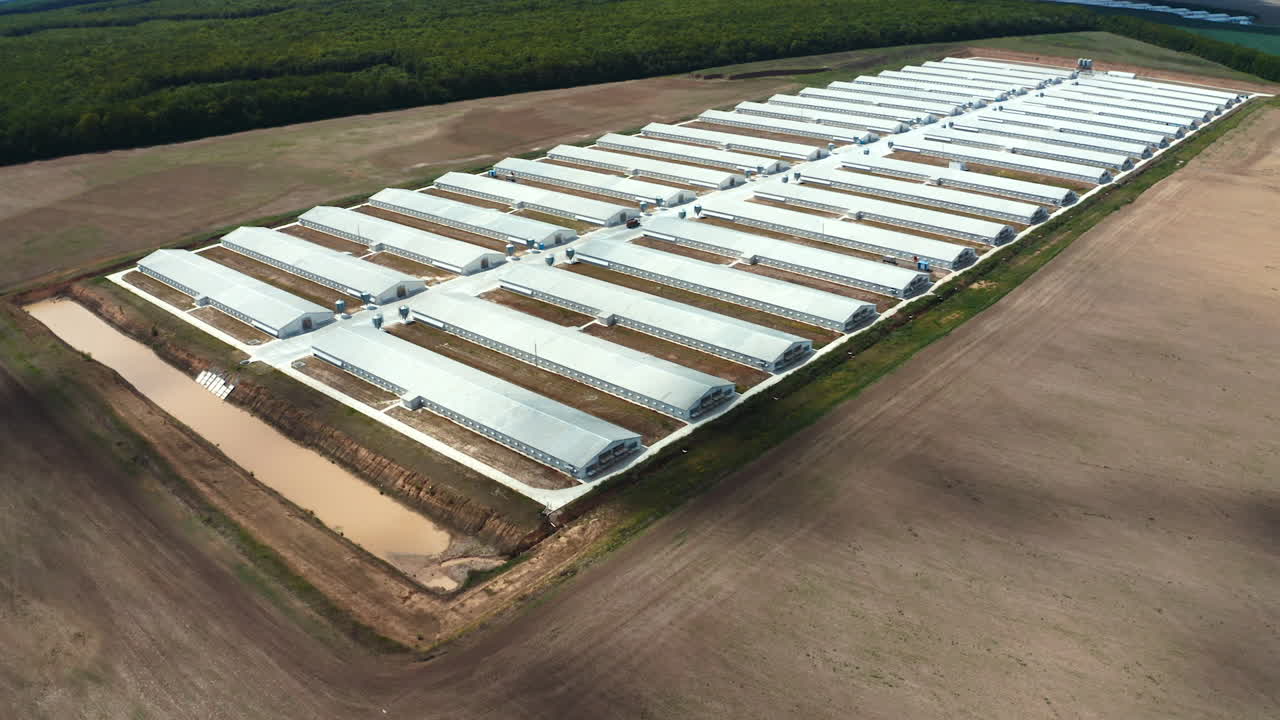 Modern production plant on the field. White buildings of innovative factory on nature background. Aerial view.