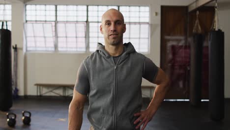 Retrato-De-Un-Hombre-Caucásico-En-Forma-Con-Las-Manos-En-Las-Caderas-Sonriendo-En-El-Gimnasio