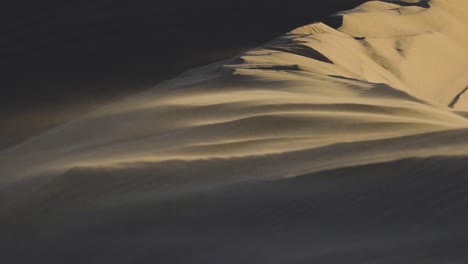 cerca de la arena que sopla en el viento en cámara lenta en una duna de arena gigante en el parque nacional del pequeño sahara en juab, utah