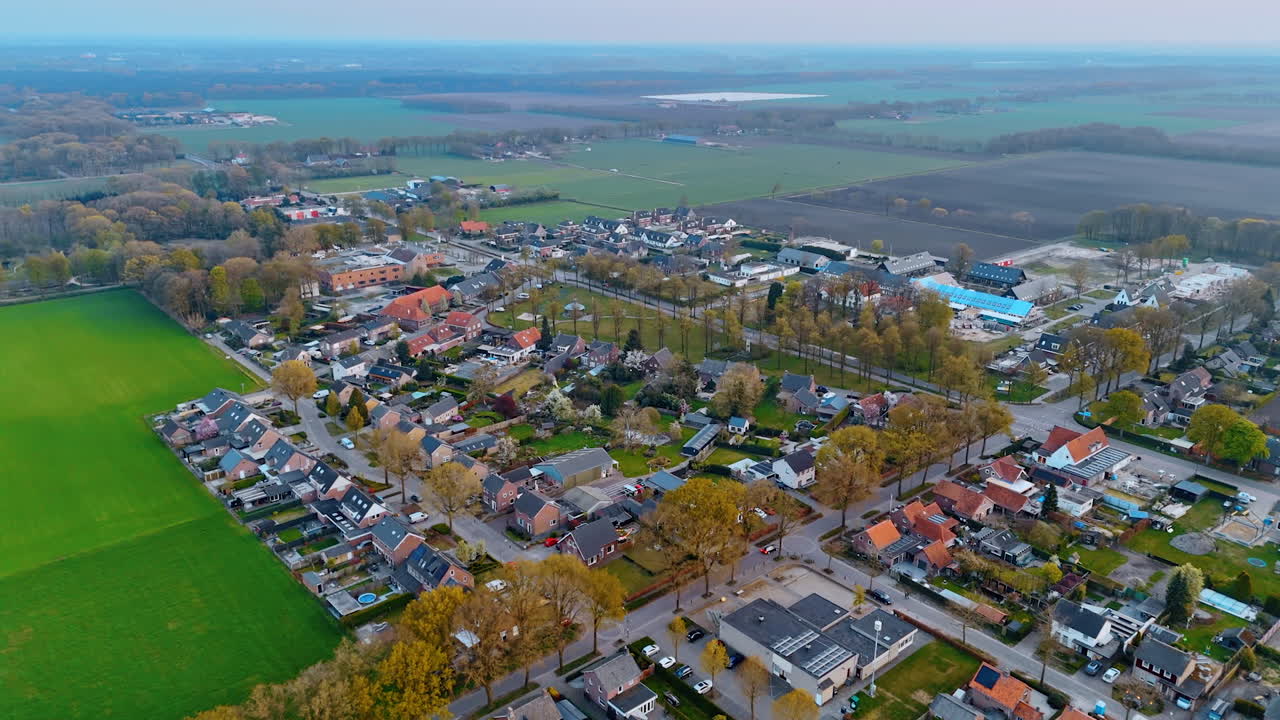 Aerial view of a Dutch village in fall. Capturing the tranquil atmosphere of a Dutch village surrounded by lush fields and diverse architecture during autumn