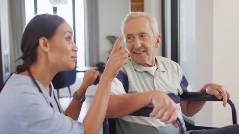 animation of happy biracial female doctor taking care of caucasian senior man