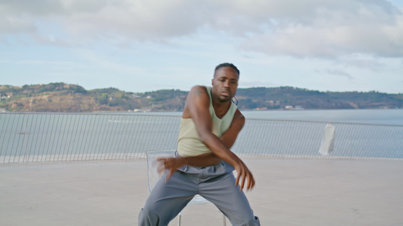 Ritratto verticale di un ballerino di balletto che si esibisce con vista mare. Ballerino di moda in assolo.