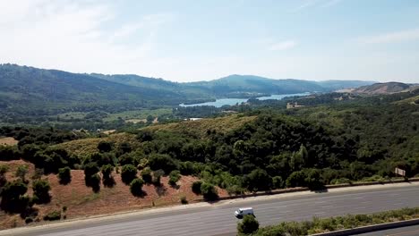 mountains highway traffic and lake at crystal spring reservoir aerial drone move forward
