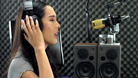 Asian-Teenager-Woman-wrapped-black-long-hair-sing-a-song-loudly-with-power-sound-over-hanging-microphone-condenser-and-equipment