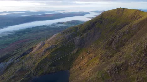 Aerial-4K-drone-video-of-mountain-in-golden-hour-with-beautiful-cloud-inversion-in-valleys---taken-at-Old-Man-of-Coniston,-Lake-District,-UK