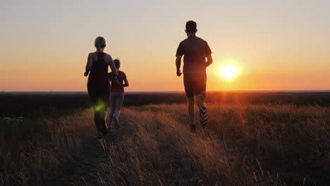 active family jogging together at sunset