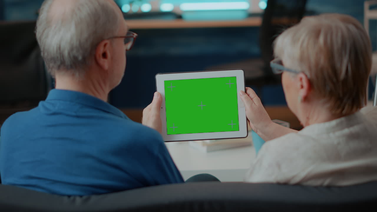Elderly couple using tablet with green screen