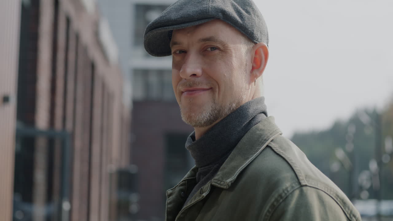 Man in a cap smiling in a city