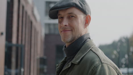 man in a cap smiling in a city