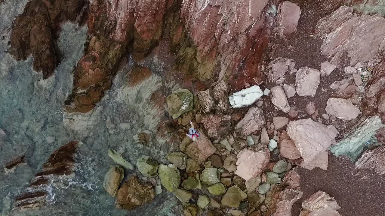 Vista aerea di una persona su una costa rocciosa