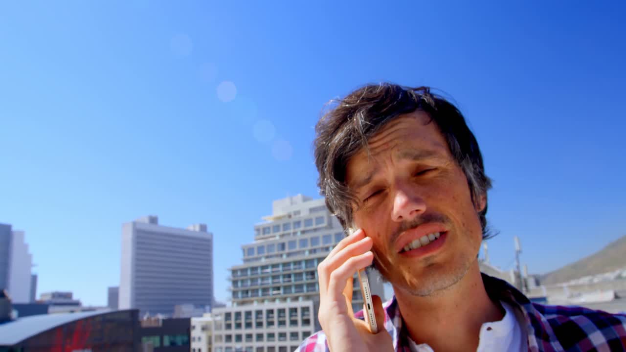 테라스 4k에서 휴대 전화로 이야기하는 남성 사진작가