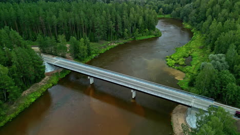 Imágenes-Aéreas-De-Un-Puente-Sobre-Un-Río-Entre-Dos-Bosques-De-Pinos.