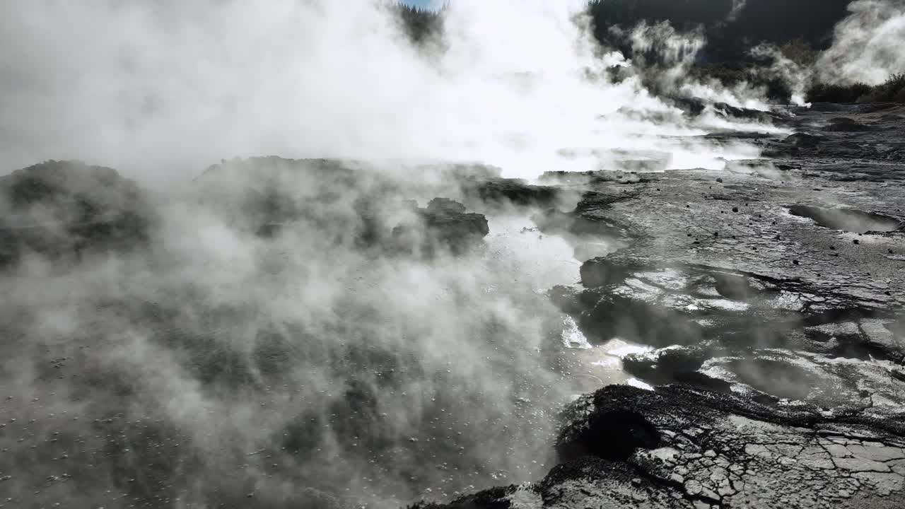Steamy bubbling mud, Drone slowly flying over geothermal landscape. Trees, steam, bubbling mud and steam. Alien Landscape. Sci-fi. Global Warming