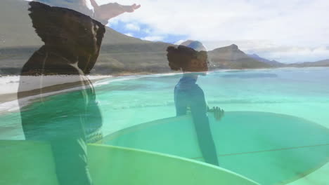 Surfers holding surfboards in shallow water, showing animated technology wave chart with ocean data