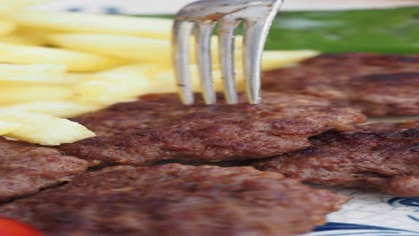 primer plano de un plato de albóndigas con papas fritas