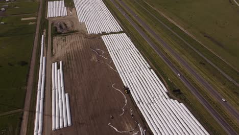 aerial birds eye shot of plastic foil covering farmland beside highway road with cars,4k