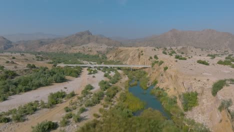 Forward-drone-shot-of-Sindh-countryside-with-a-bridge-in-Pakistan