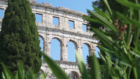 pula arena wall from behind bushes, croatia