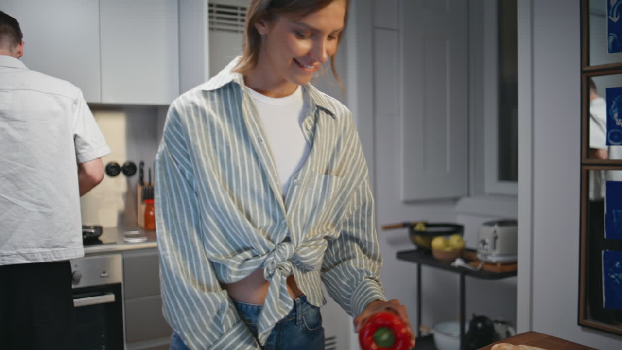 Woman juggling bell pepper in kitchen. Closeup hands cutting fresh vegetables